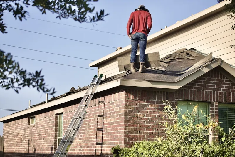 Professional roofer working on a residential roof in The Acreage